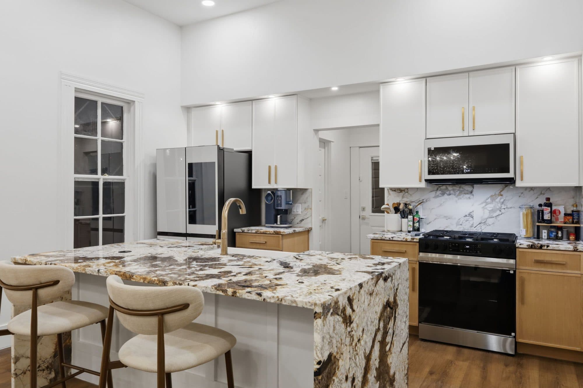 Kitchen with waterfall granite island and custom cabinetry at 917 Burnet Street