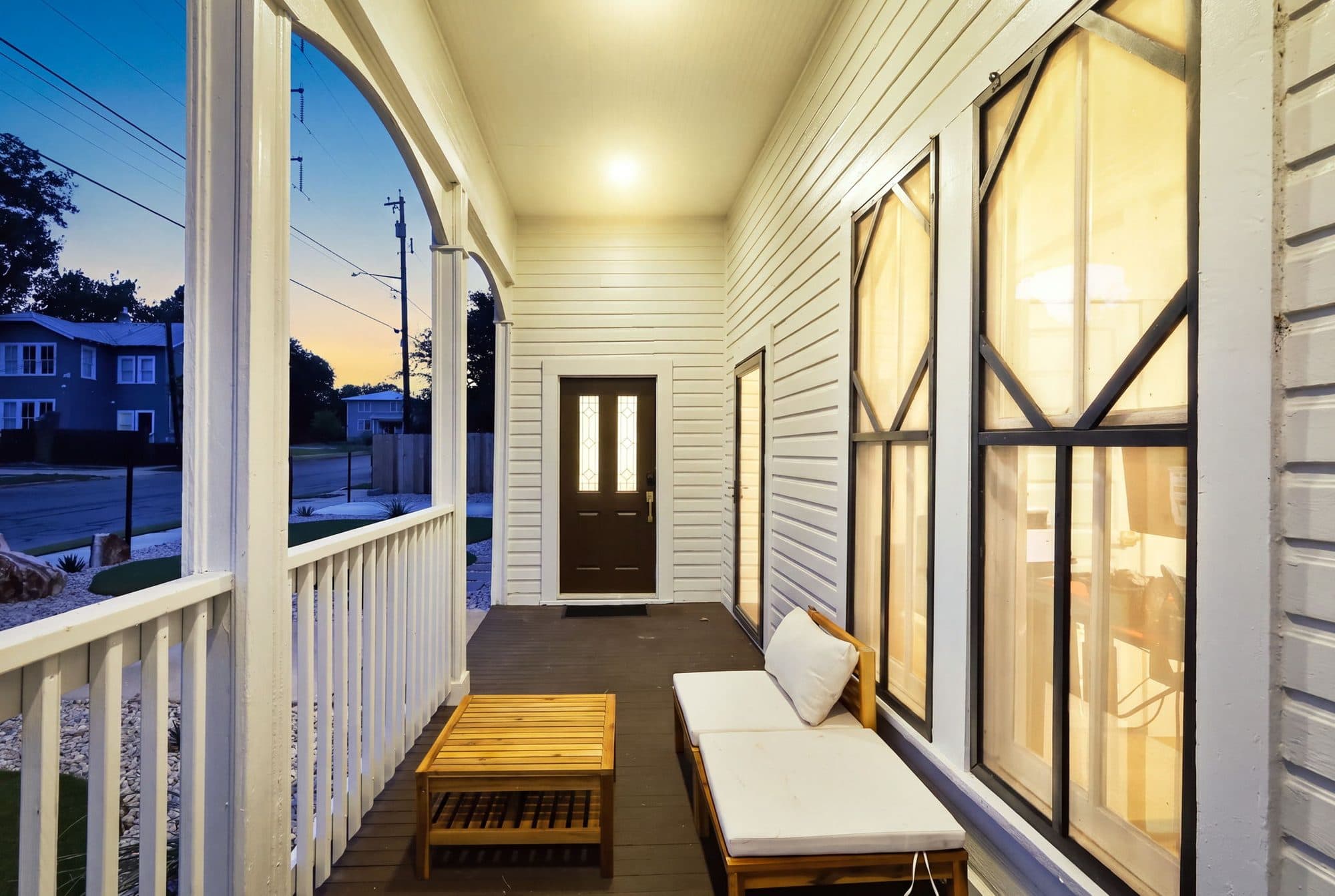 Wraparound porch seating at 917 Burnet Street in the evening