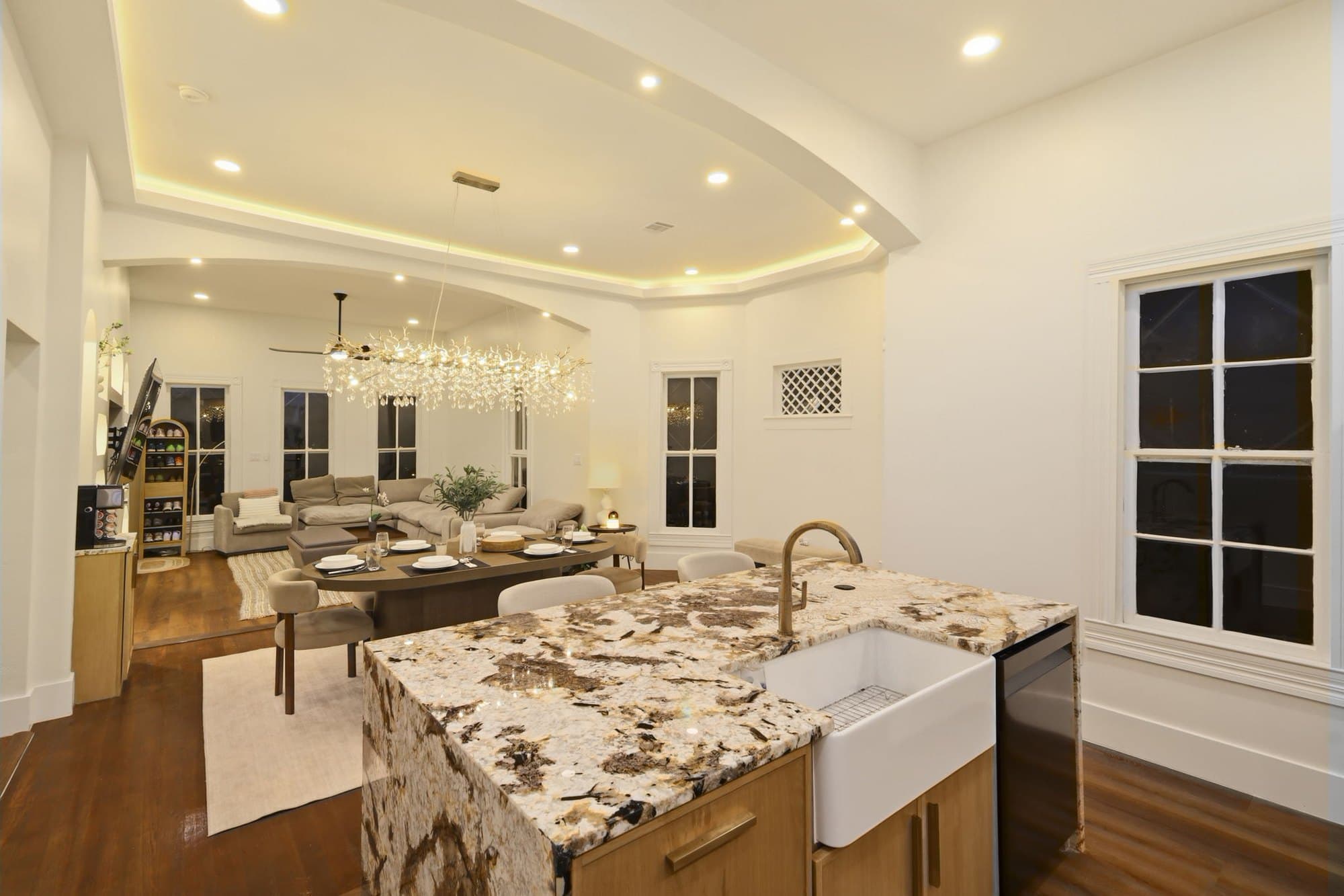 Kitchen with a waterfall granite island and brass fixtures