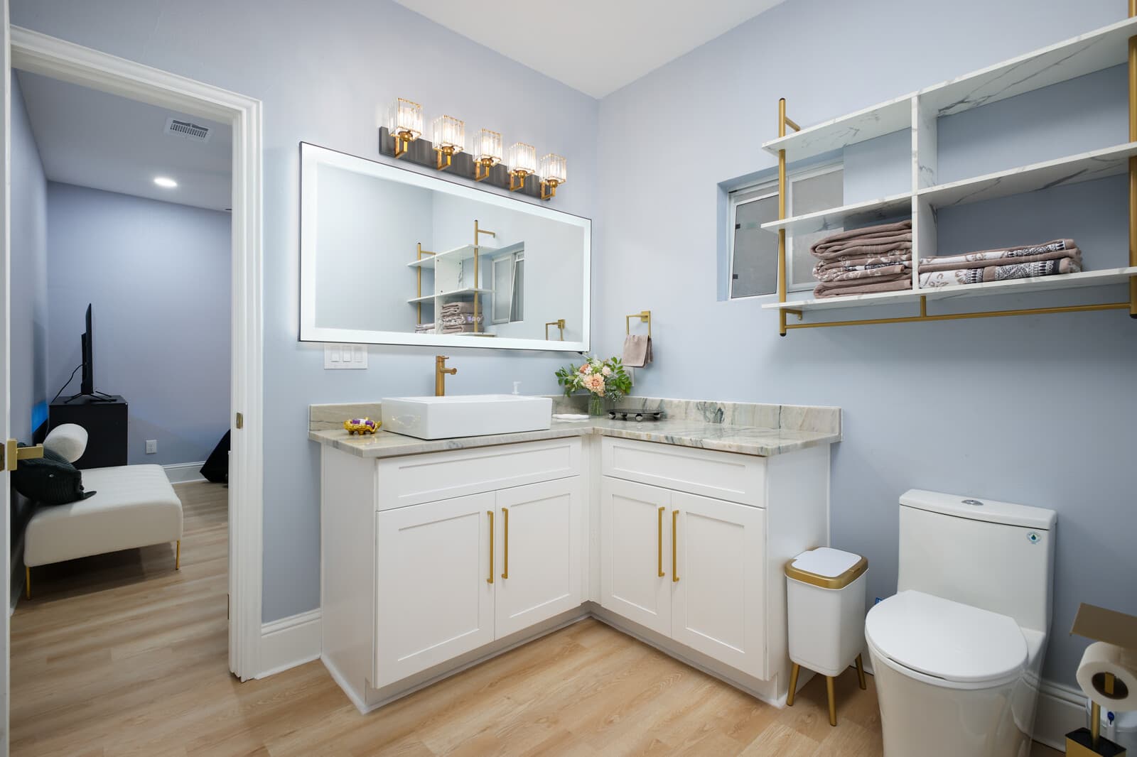 Full bathroom with a double vanity, white cabinetry and brass fixtures